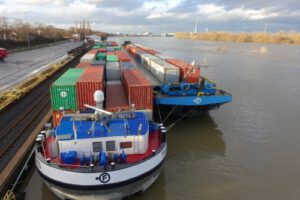 Das Bild zeigt zwei beladene Containerschiffe am Niehler Hafen in Köln.